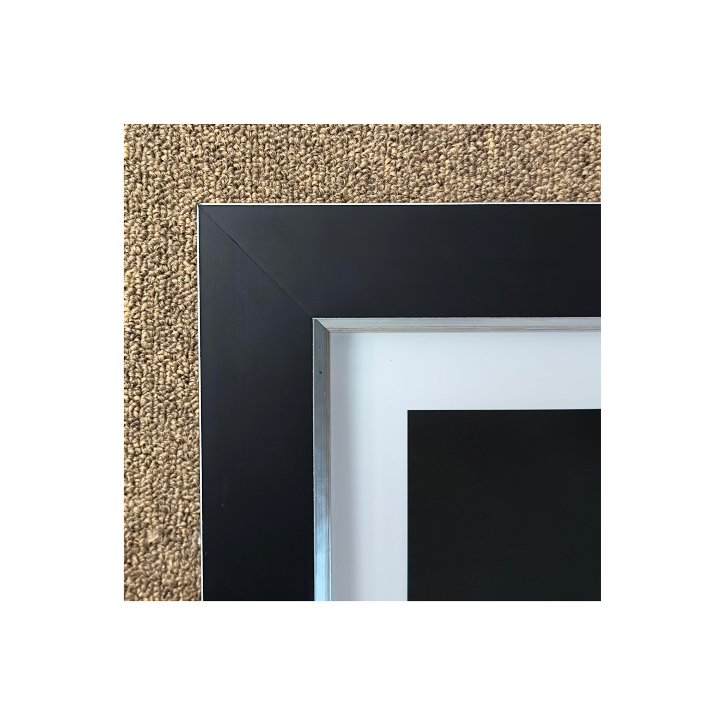 A black frame photographed on a carpet.